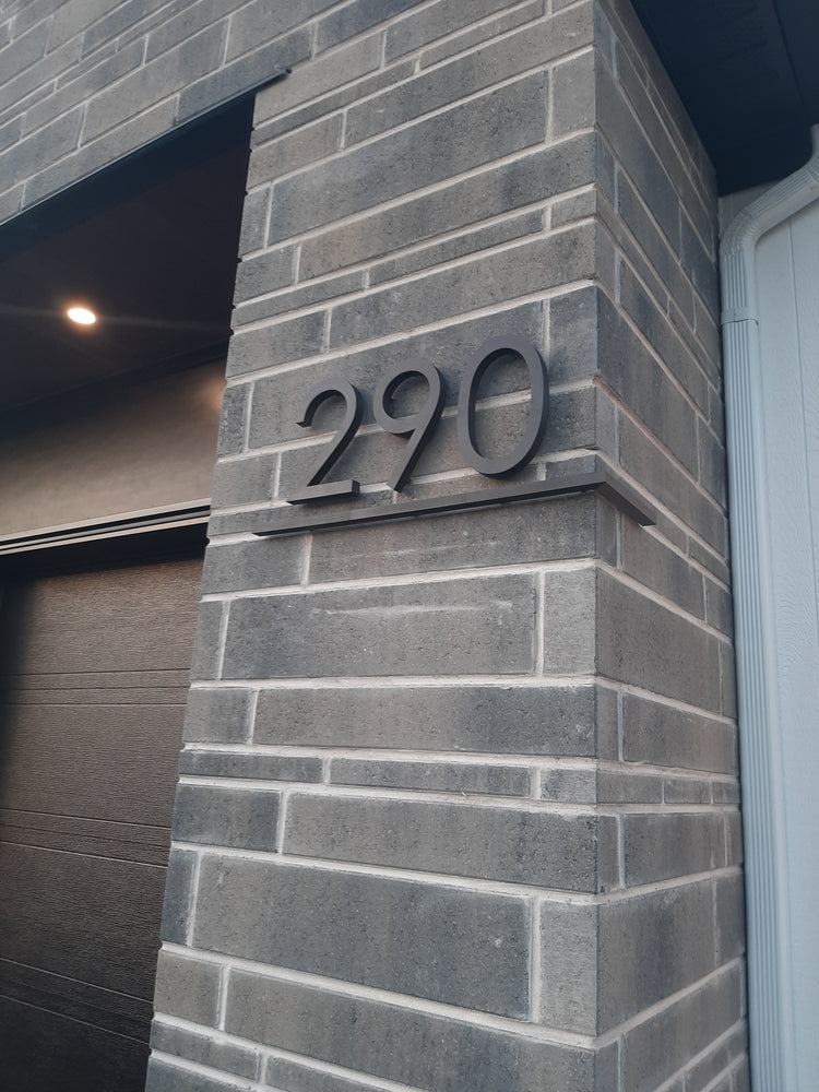 Numéro civique 290 souligné installé sur une façade en brique